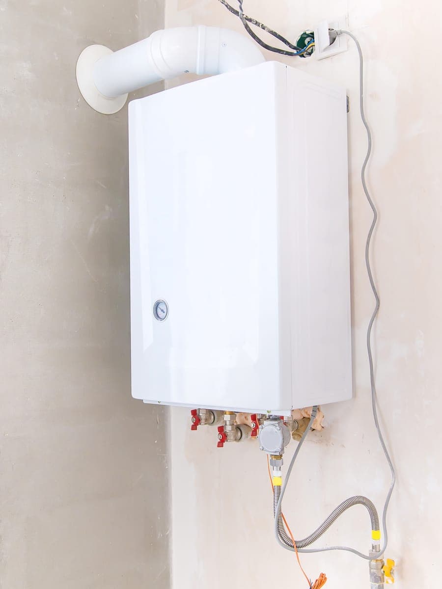 A modern wall hung gas boiler in a domestic utility room