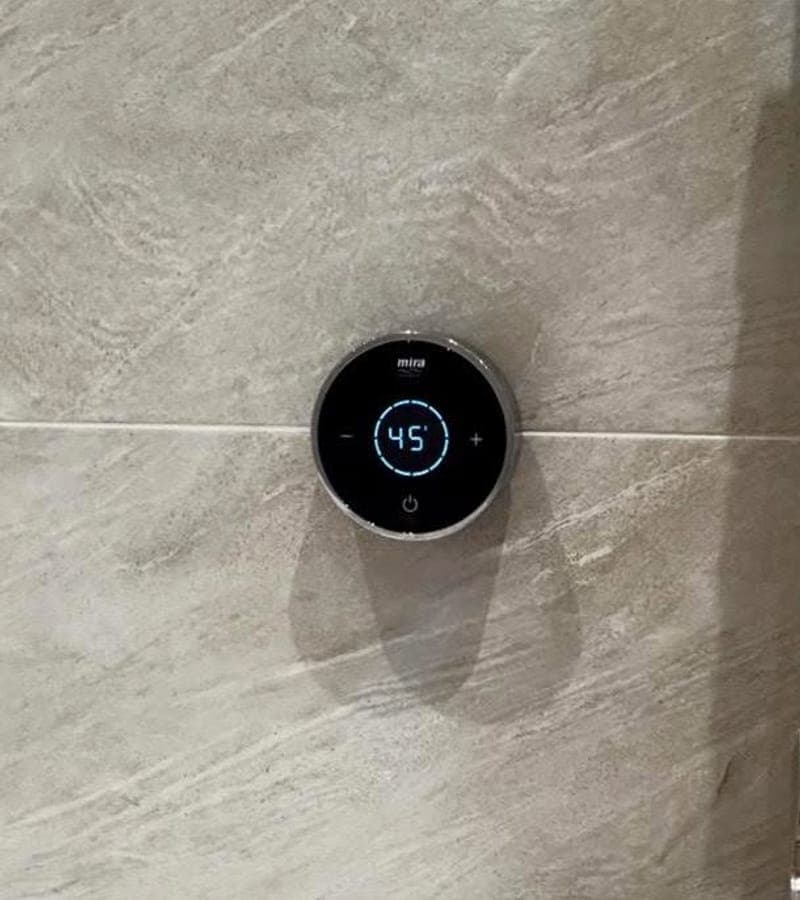 A digital shower control set into stone tiling