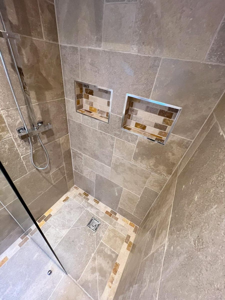 Tiled storage niches in a travertine shower