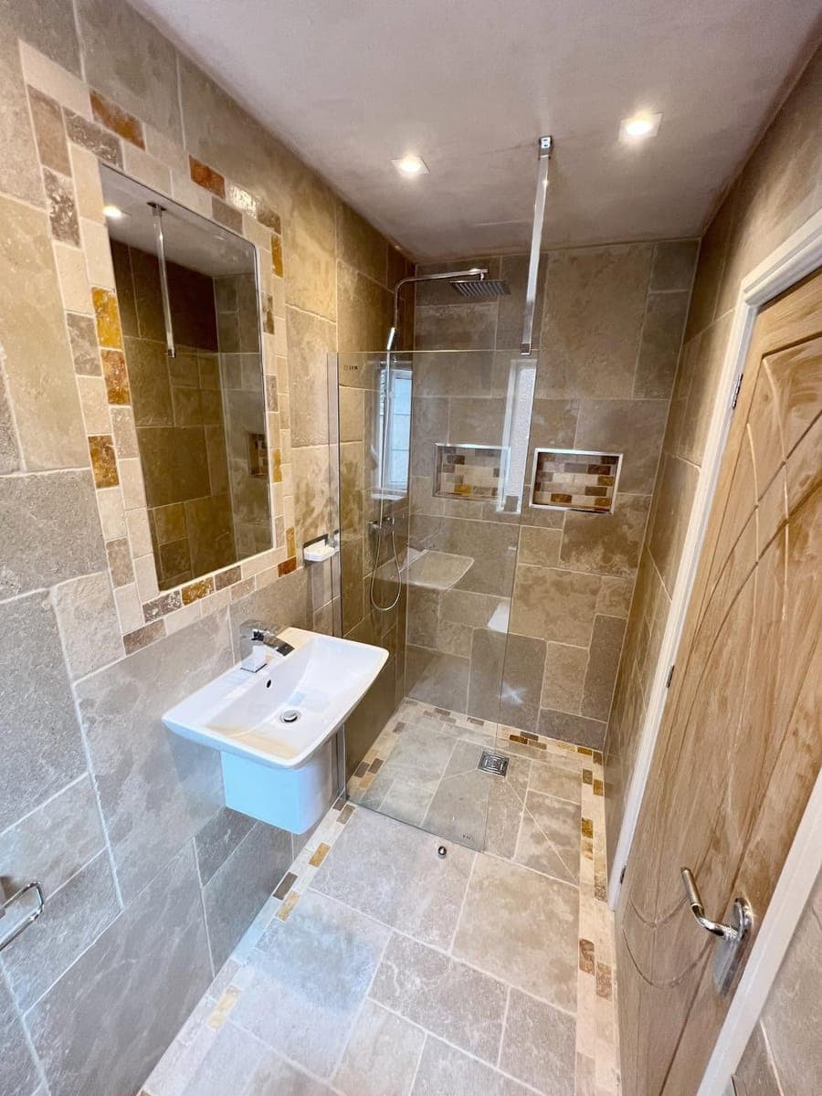 A travertine tiled shower room with a walk in shower, fitted by Askern Plumbing