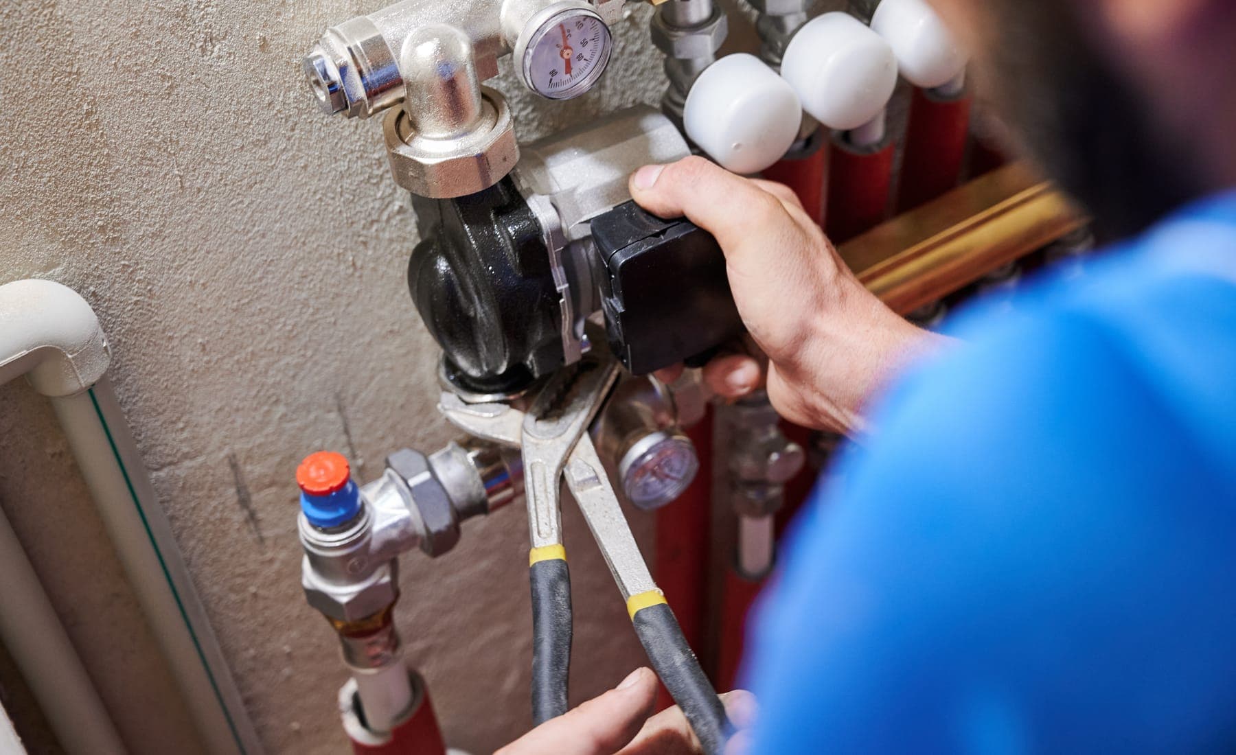 A plumber tightening a pipe fitting