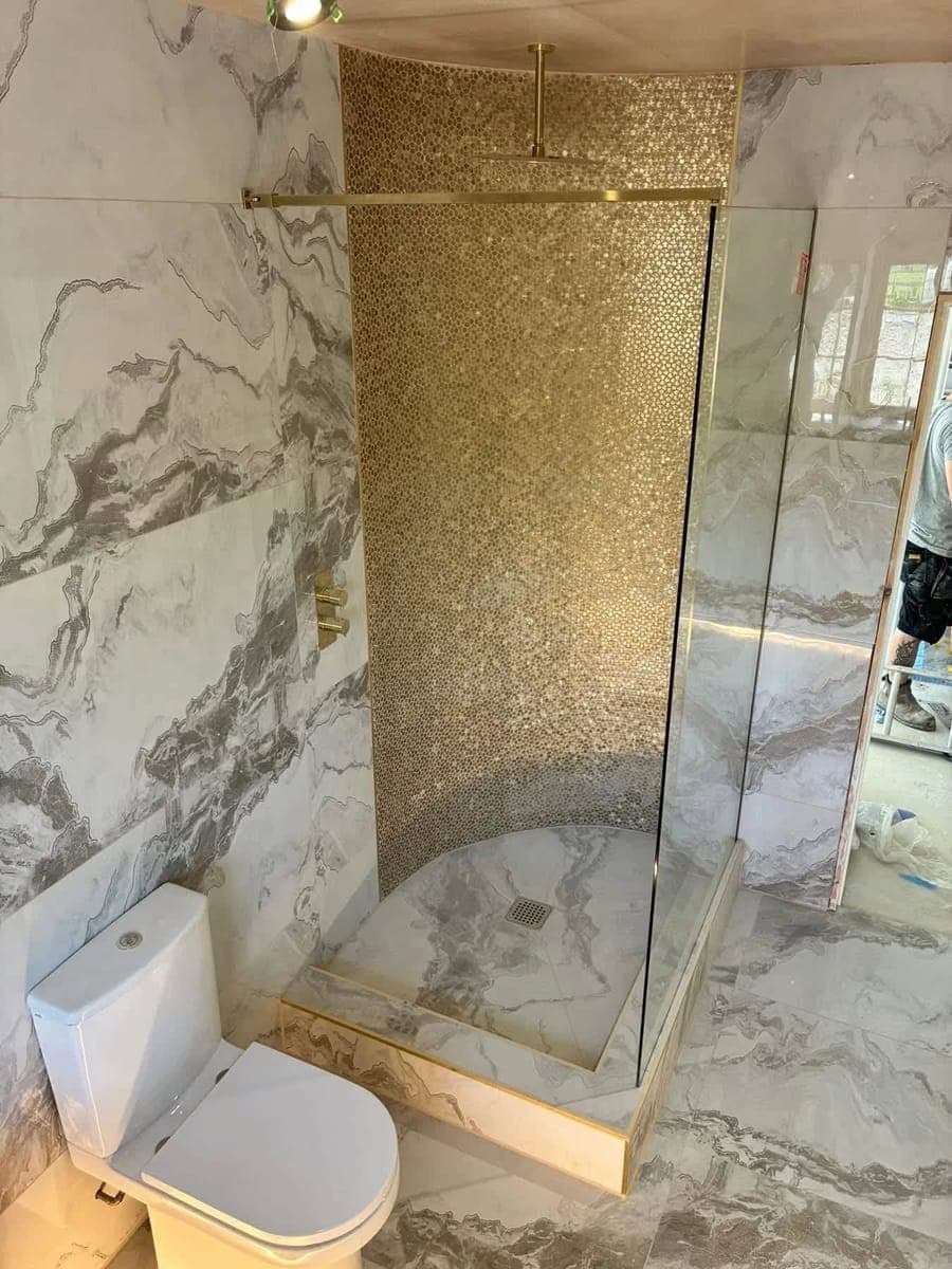 A walk in shower with a gold penny mosaic feature wall, fitted by Askern Plumbing